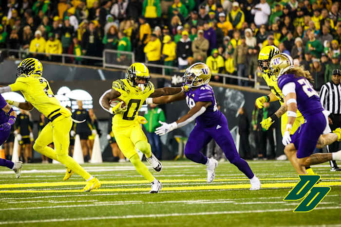 Oregon Ducks running back Bucky Irving uses a stiff arm against the Washington Huskies.